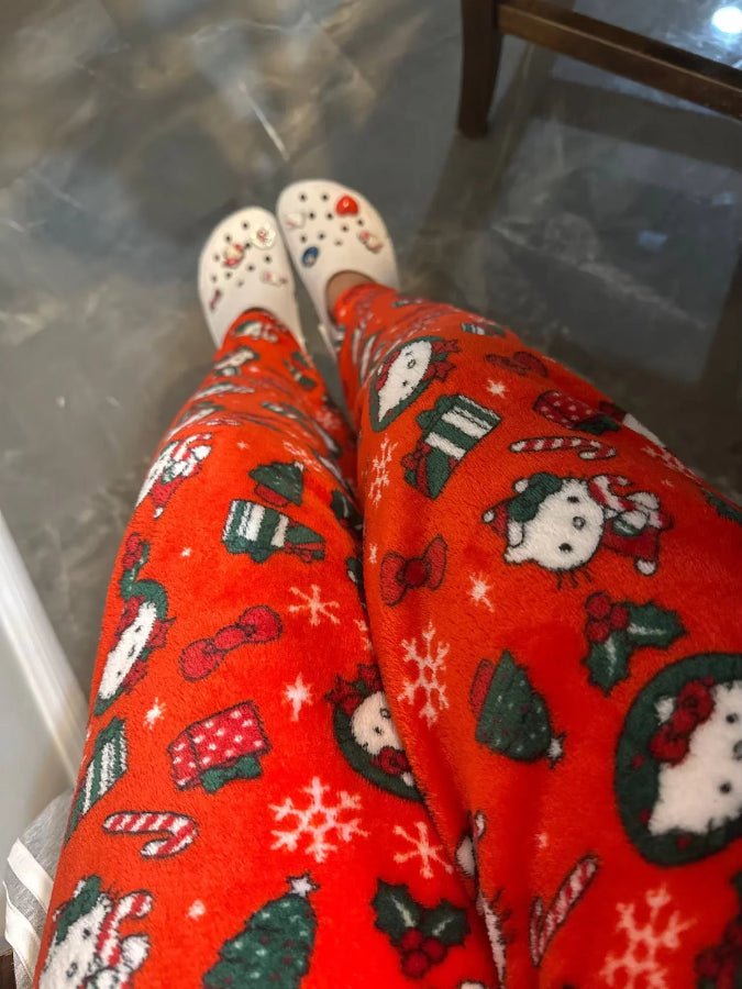 Red patterned pants with Christmas-themed designs on a glass floor.