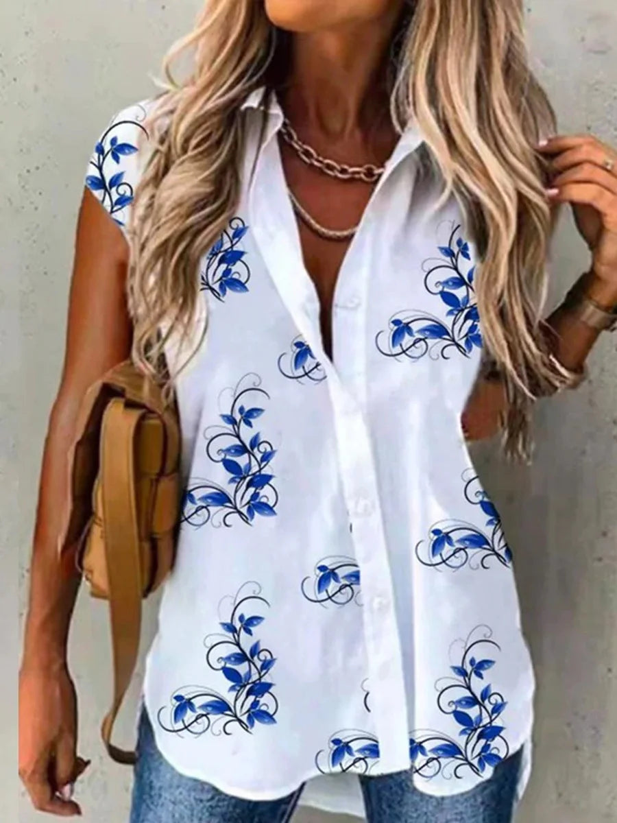 Woman wearing a white blouse with blue floral patterns against a neutral background