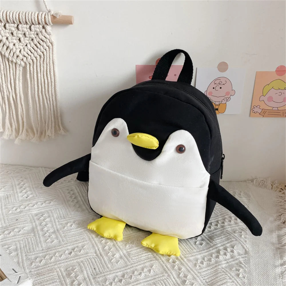 Penguin-shaped backpack on a textured surface with a light-colored wall in the background