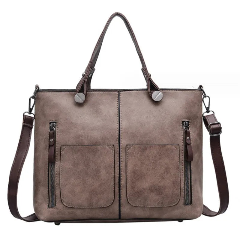 Brown leather handbag with two front pockets on a white background
