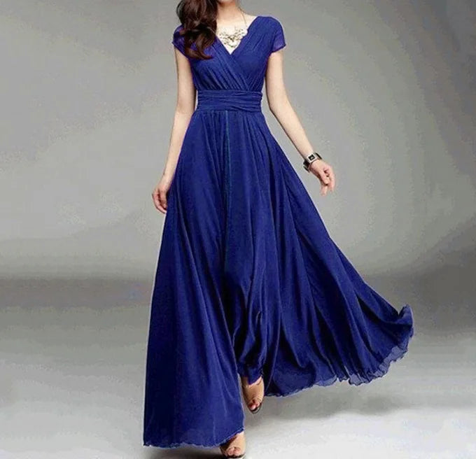 Woman wearing a flowing blue dress on a plain background