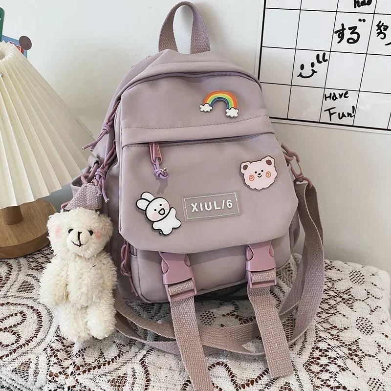 Light purple backpack with decorative pins on a patterned surface