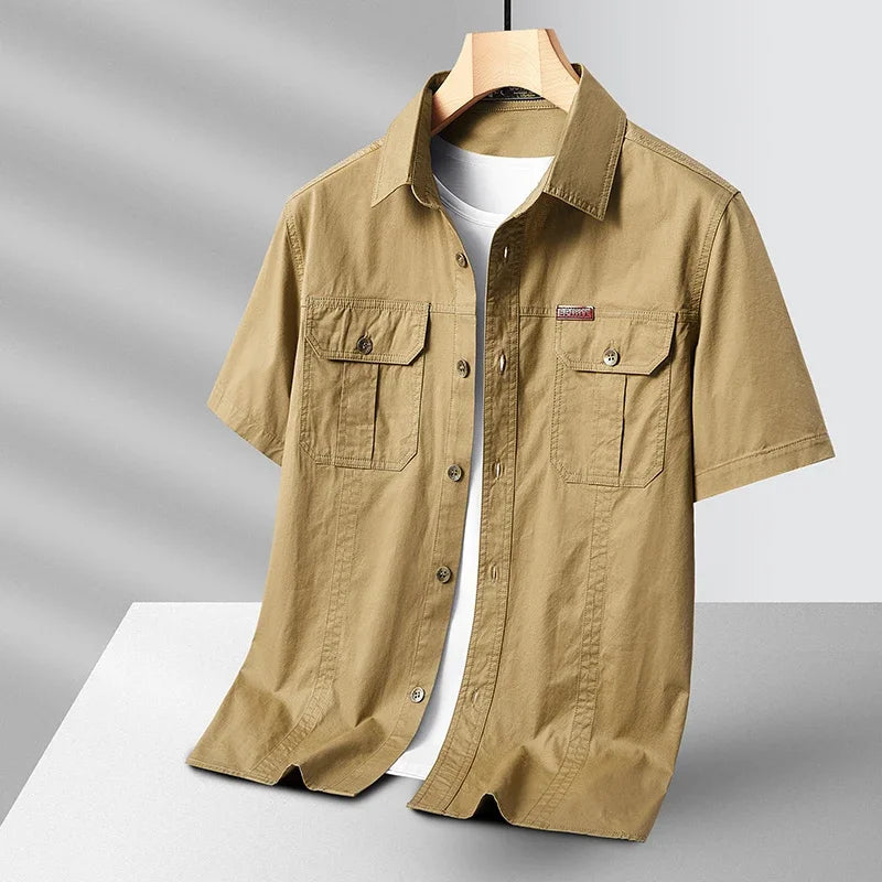 Beige short-sleeve shirt on a hanger against a gray background