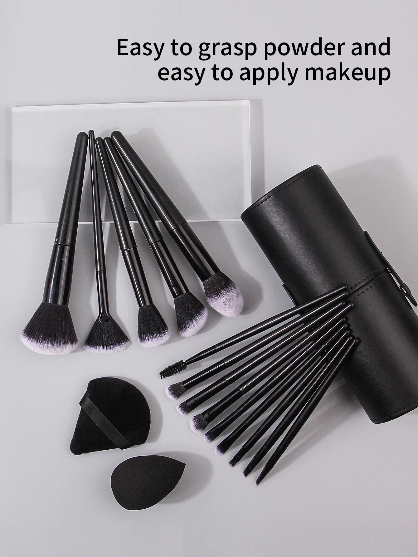 Set of black makeup brushes with a black cylindrical holder on a light gray background.