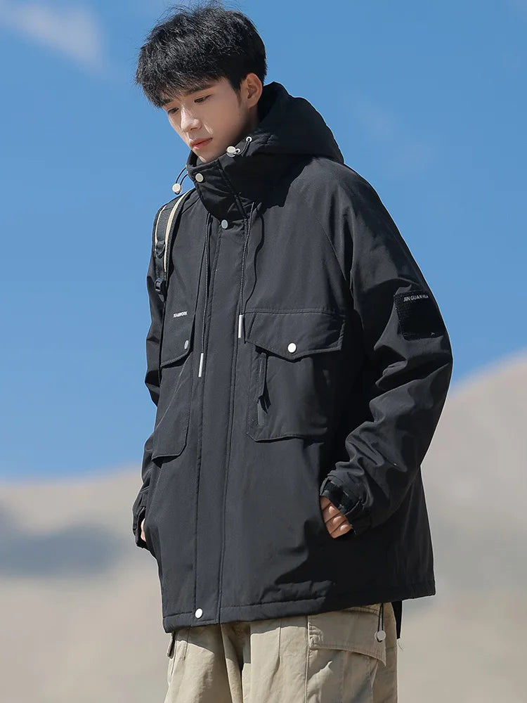 Person wearing a black jacket against a blue sky with clouds