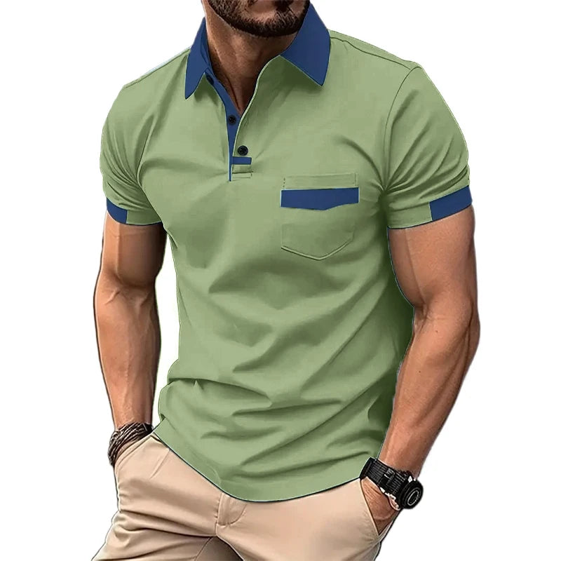 A man wearing a short-sleeved beige polo shirt with blue collar and pocket trim, and light beige shorts.