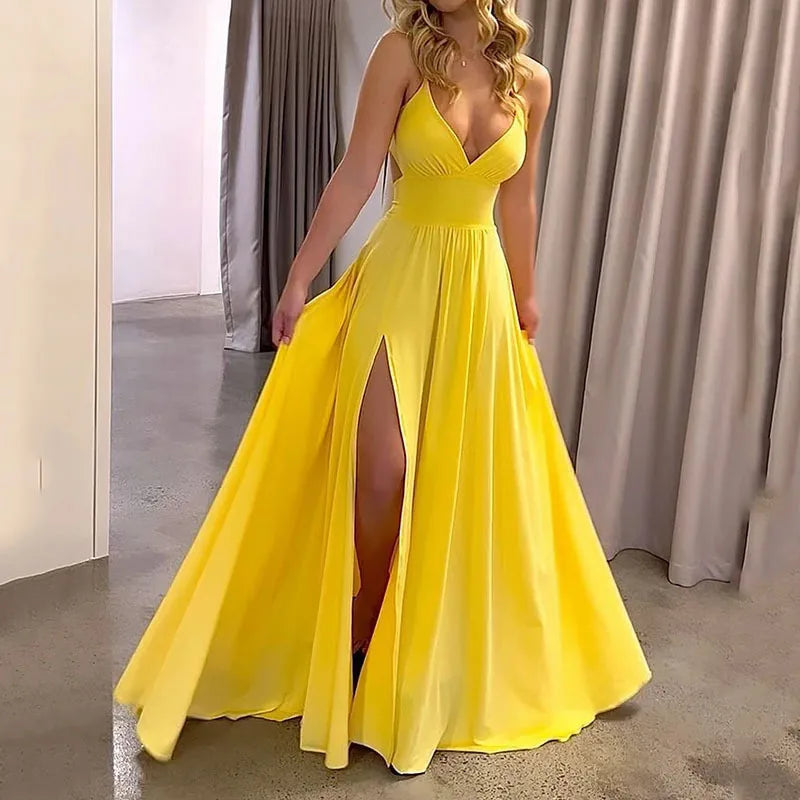 Woman wearing a yellow evening gown with a slit, standing against a neutral background.