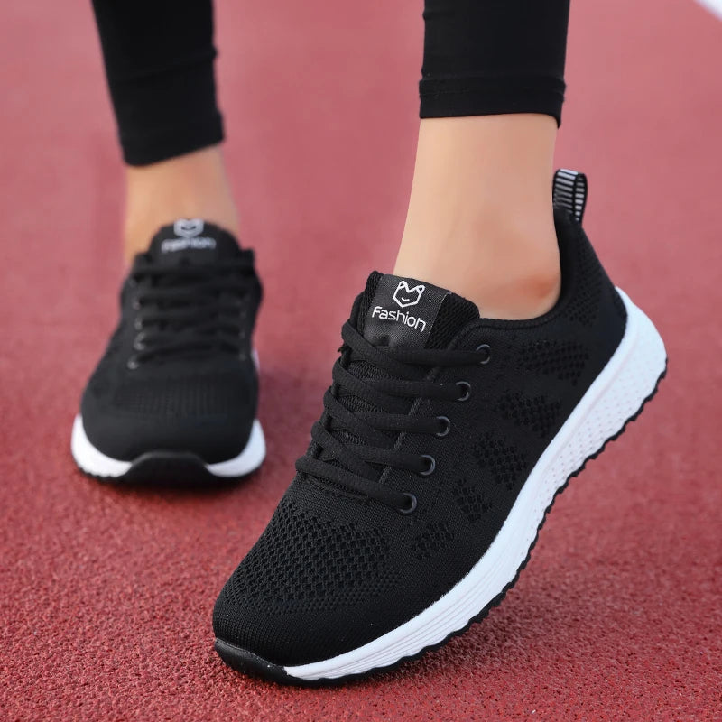 Black running shoes with white soles on a red surface