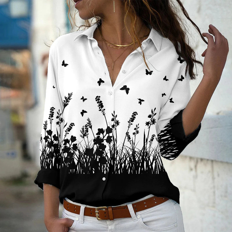 White shirt with black floral pattern worn by a person, blurred background