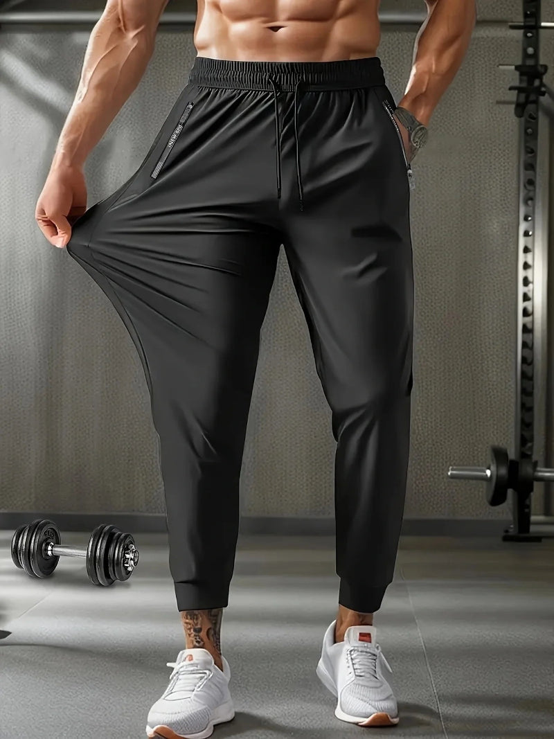 Person wearing black athletic pants with a gray background