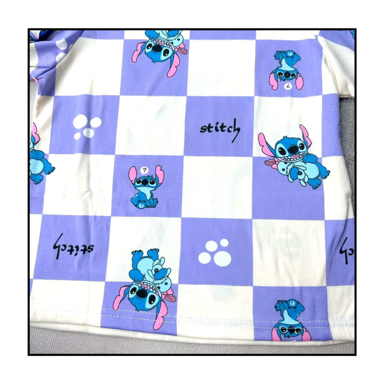 Checkered blanket with cartoon character and 'stitch' text on a purple and white background