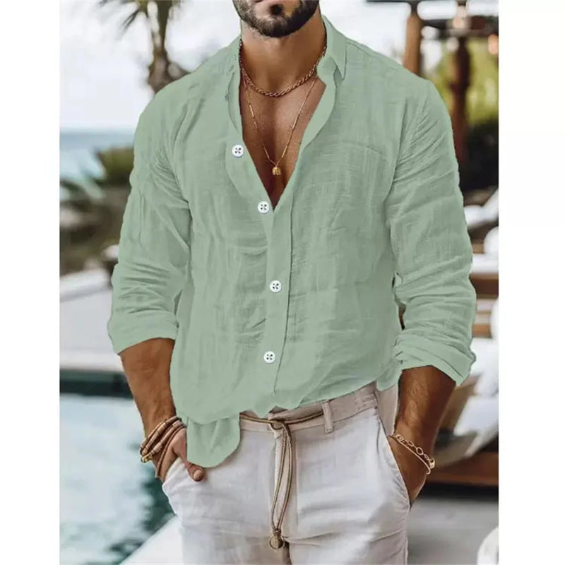 Man wearing a light green button-up shirt and beige pants by a poolside.