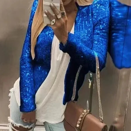 Person wearing a blue sequin jacket with a neutral background