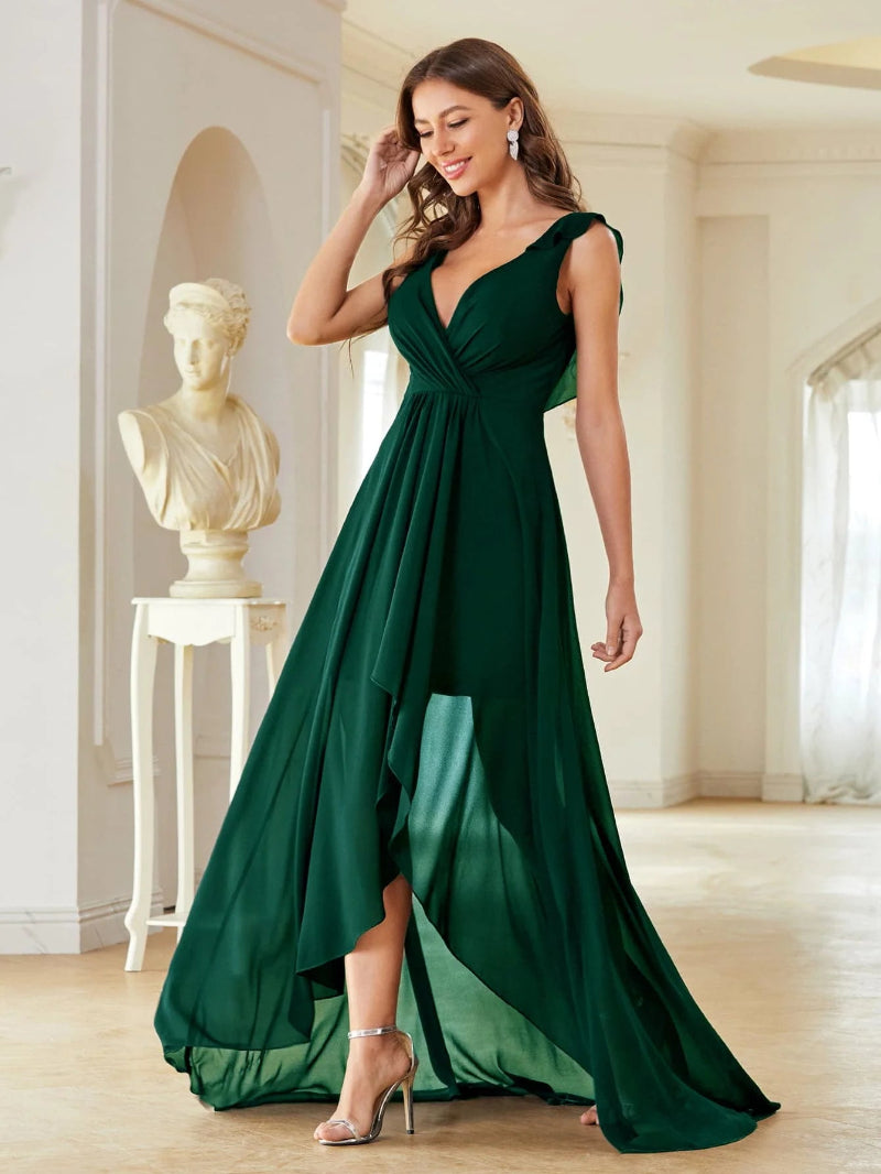 Woman wearing a green evening gown in an elegant room with classical sculpture.
