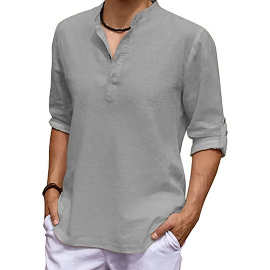 Person wearing a gray long-sleeve shirt with rolled-up sleeves on a white background