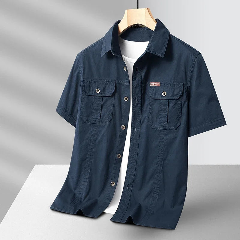 Navy blue short-sleeve shirt on a hanger against a gray background