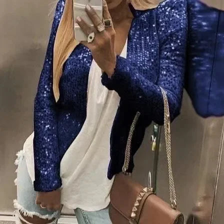 Person wearing a blue sequin jacket taking a mirror selfie.