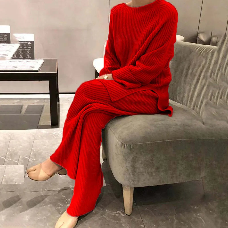 Mannequin wearing a red outfit sitting on a gray chair in an indoor setting.