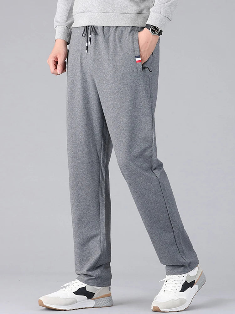 Person wearing gray sweatpants on a plain background