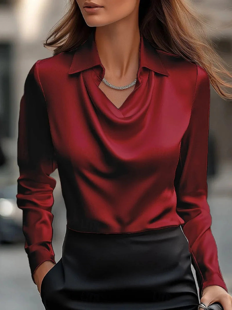 Red long-sleeve top worn by a person with a blurred background
