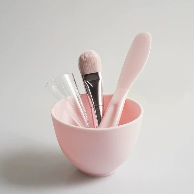 Pink makeup brush set with a bowl on a light gray background