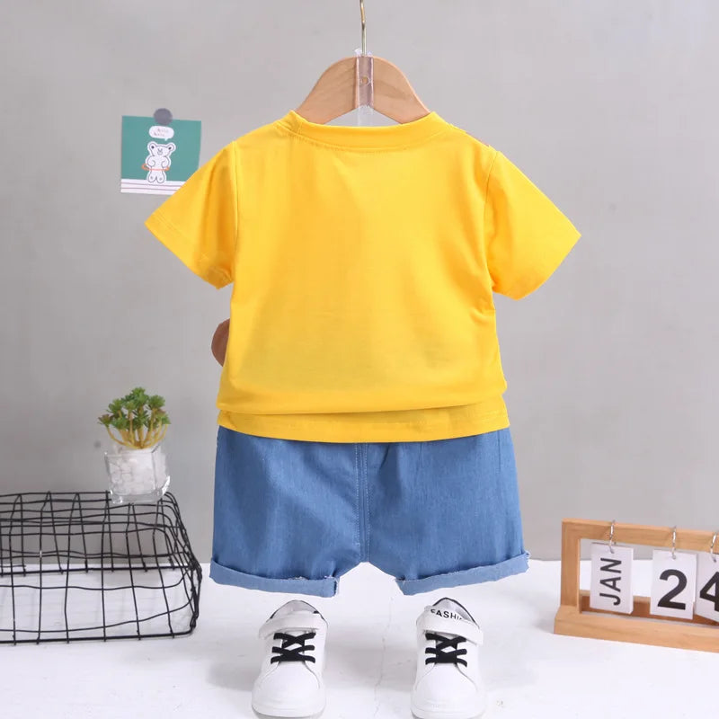 Yellow t-shirt and blue shorts set with white sneakers on a gray background