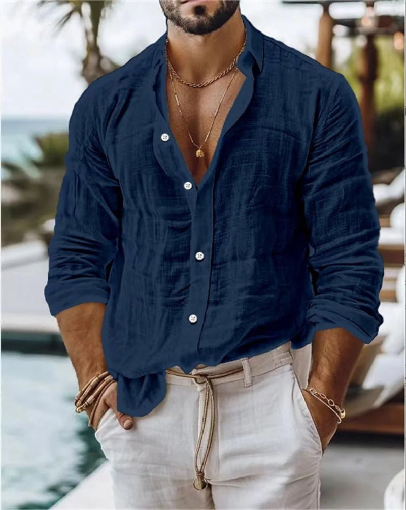 Man wearing a navy blue button-up shirt and light-colored pants by a poolside.