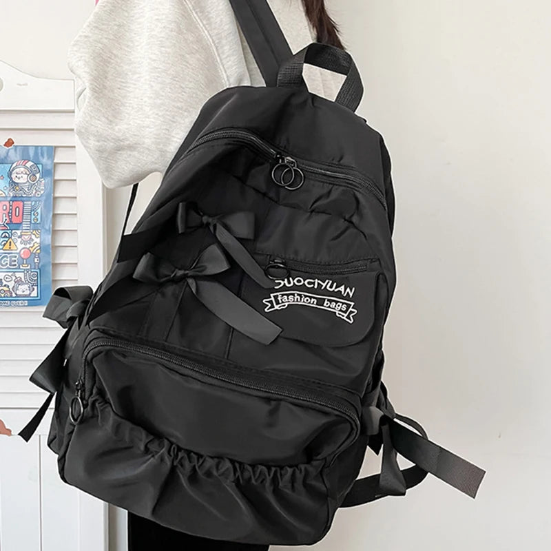 Black backpack with ruffles and 'DUOYIYUAN' branding on a white background