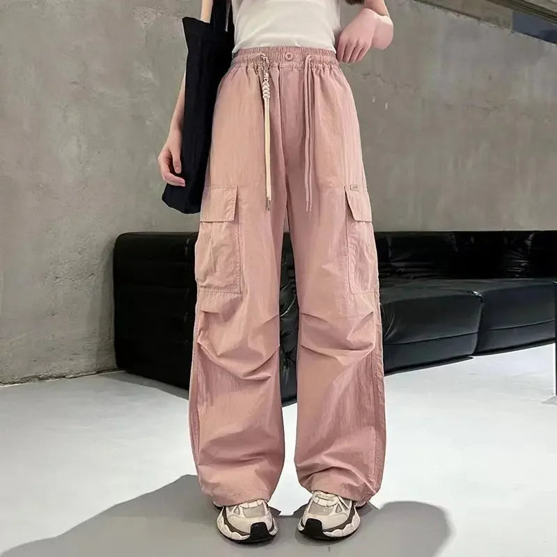 Person wearing pink cargo pants in a minimal indoor setting