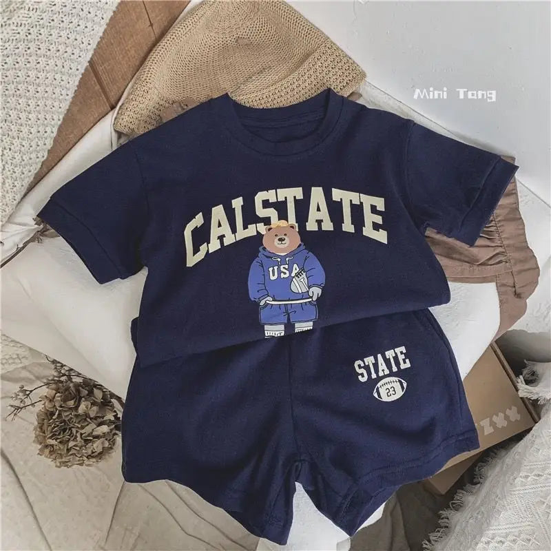 Navy blue children's outfit with 'CALSTATE' text and bear graphic on a white surface.