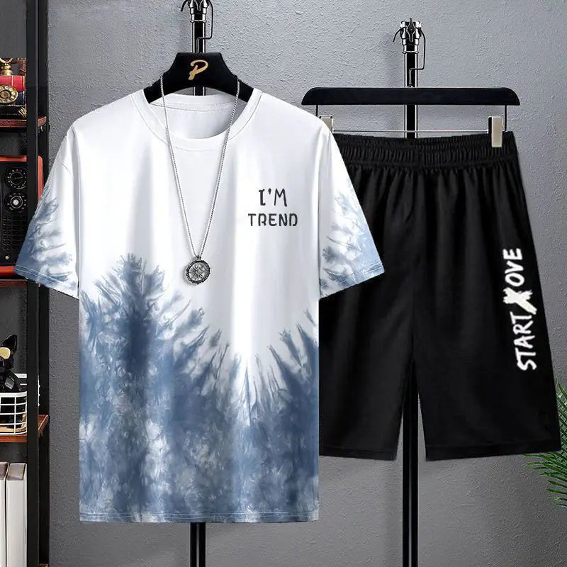 Tie-dye t-shirt and black shorts with text on hangers against a gray background