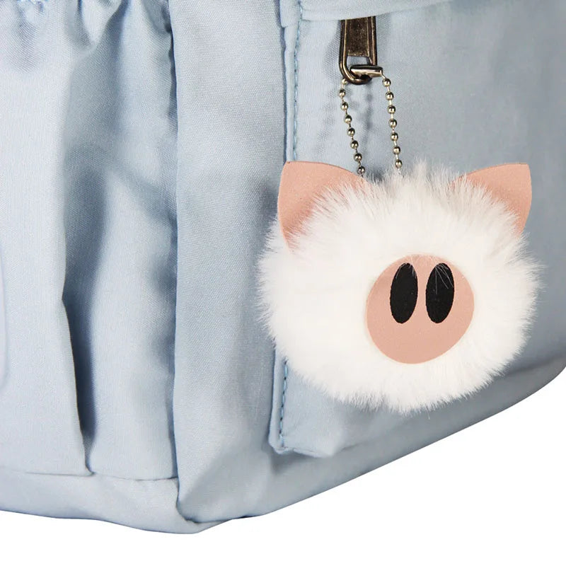 Fluffy pink cat-shaped keychain attached to a light blue bag.