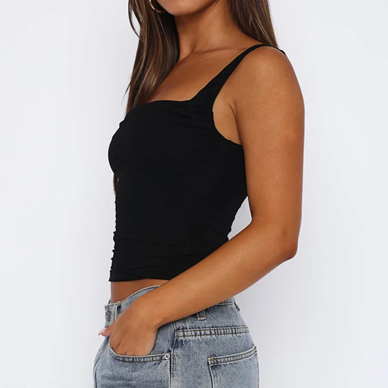 Person wearing a black tank top and light blue jeans on a white background