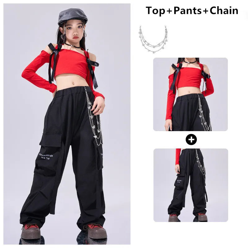 Person wearing a red top, black pants, and a chain accessory on a gray background