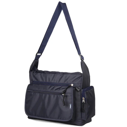 Navy blue shoulder bag with multiple zippers on a white background