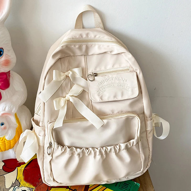 Beige backpack with ribbons on a white background