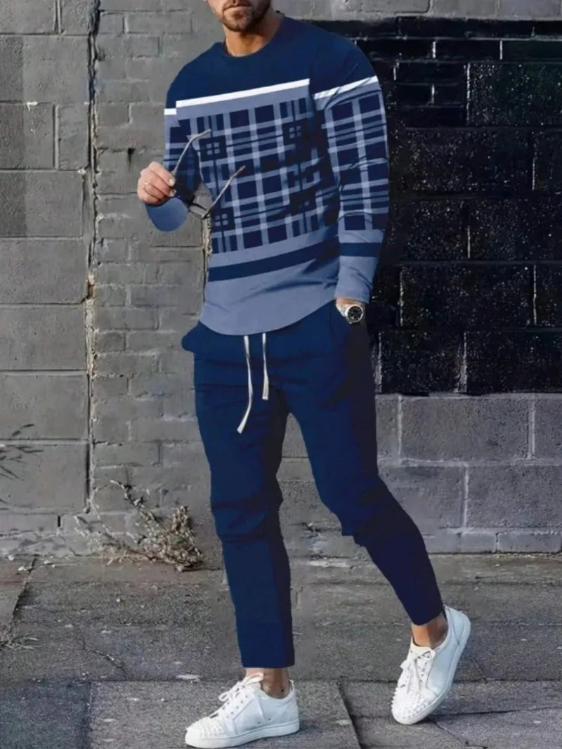 Person wearing a blue and gray checkered sweater with matching pants, standing against a brick wall.