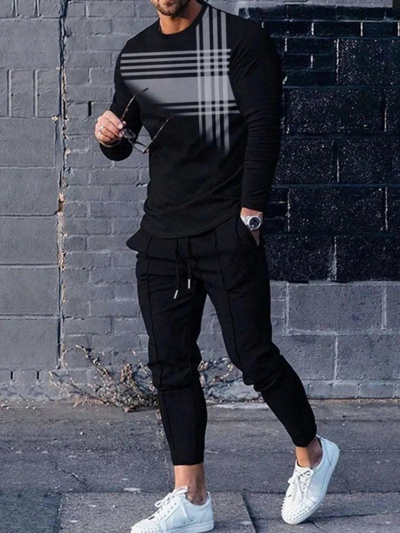 Person wearing a black outfit with plaid details against a brick wall.