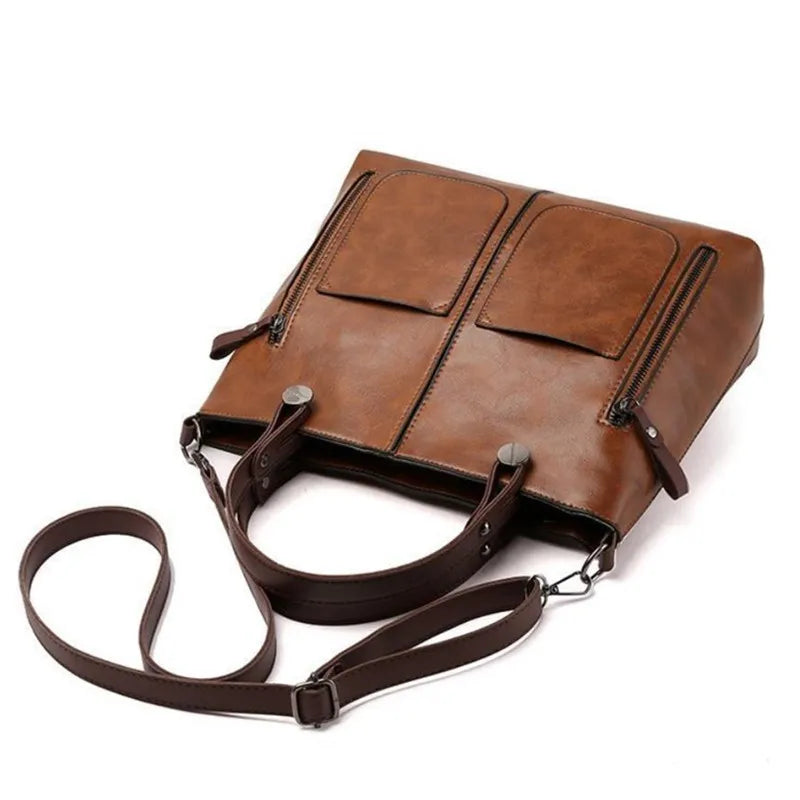 Brown leather bag with a strap on a white background