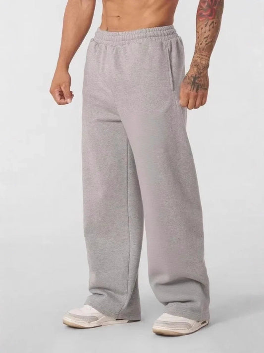 Person wearing gray sweatpants on a plain background