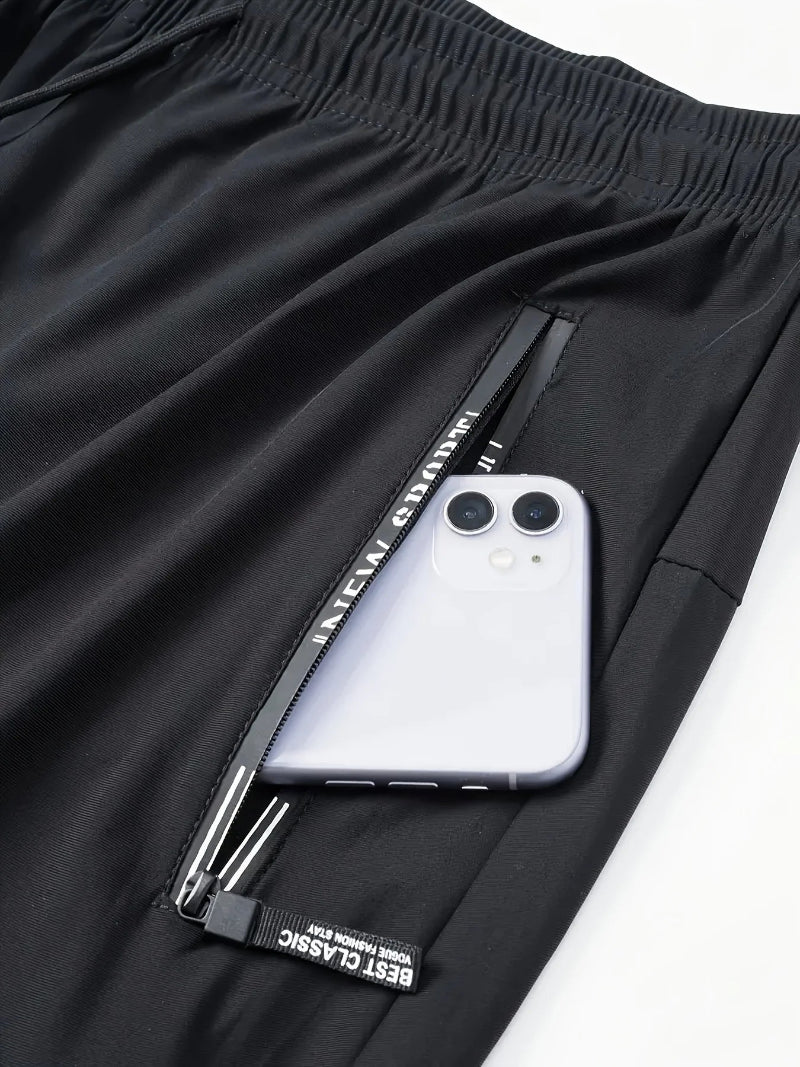 Black pants with a phone pocket containing a smartphone on a white background