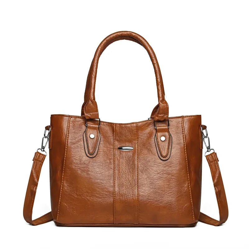 Brown leather handbag with a shoulder strap on a white background