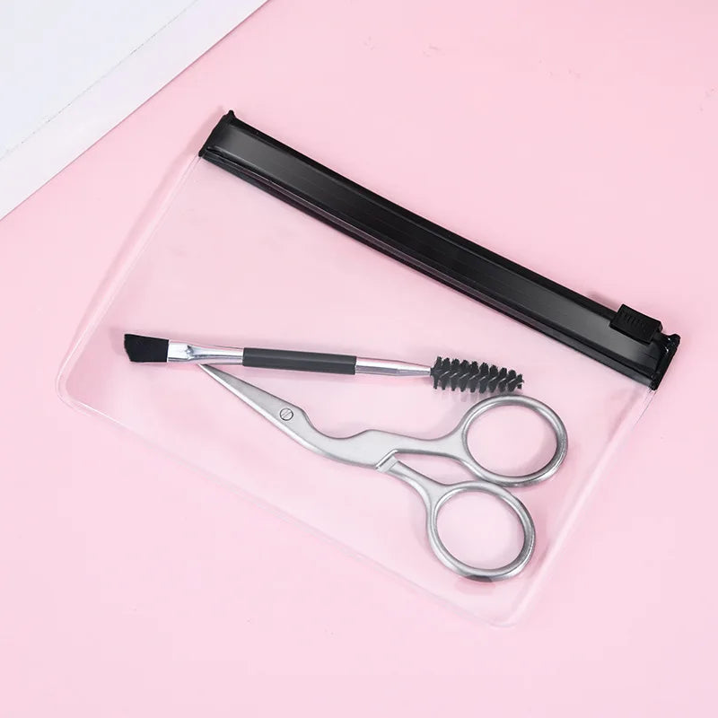 Set of scissors, brush, and comb on a pink background