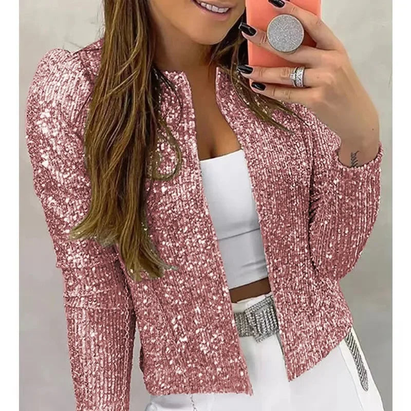 Person wearing a pink sequin jacket with a plain background