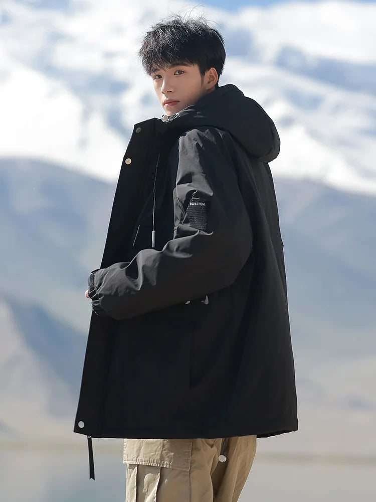 Person wearing a black coat with a snowy mountain background