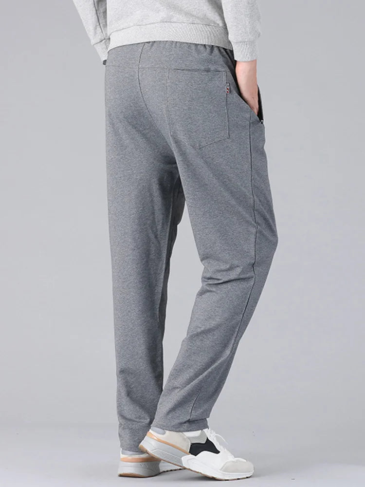 Person wearing gray pants on a plain background