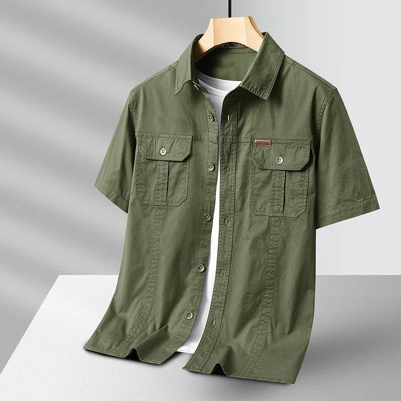 Green short-sleeve shirt on a hanger against a gray background