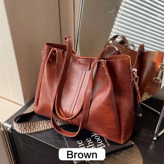 Brown leather handbag on a black surface with 'Brown' label