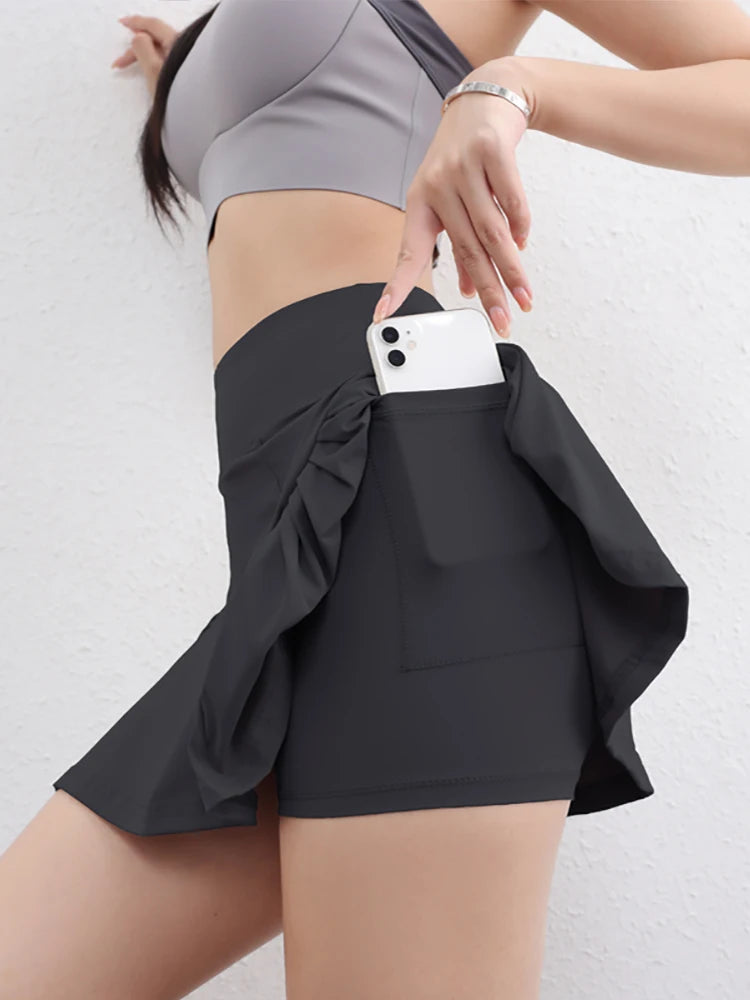 Person wearing a black skirt with a white phone in the pocket against a light background