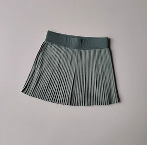 Green pleated skirt on a light gray background